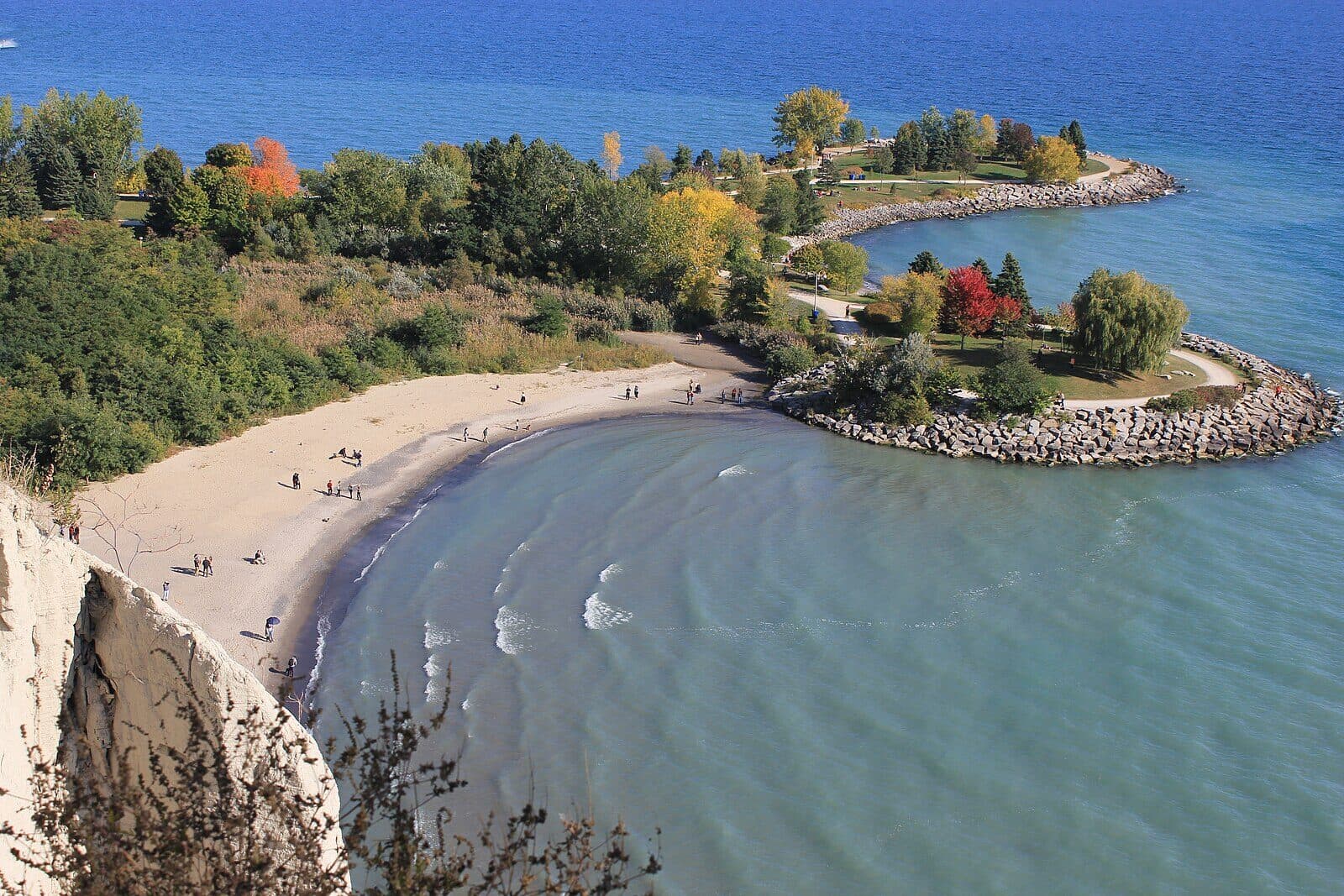 Aerial view of the white sandstone Scarborough Bluffs above the sandy beach and turquoise water at Bluffer's Park on Lake Ontario
