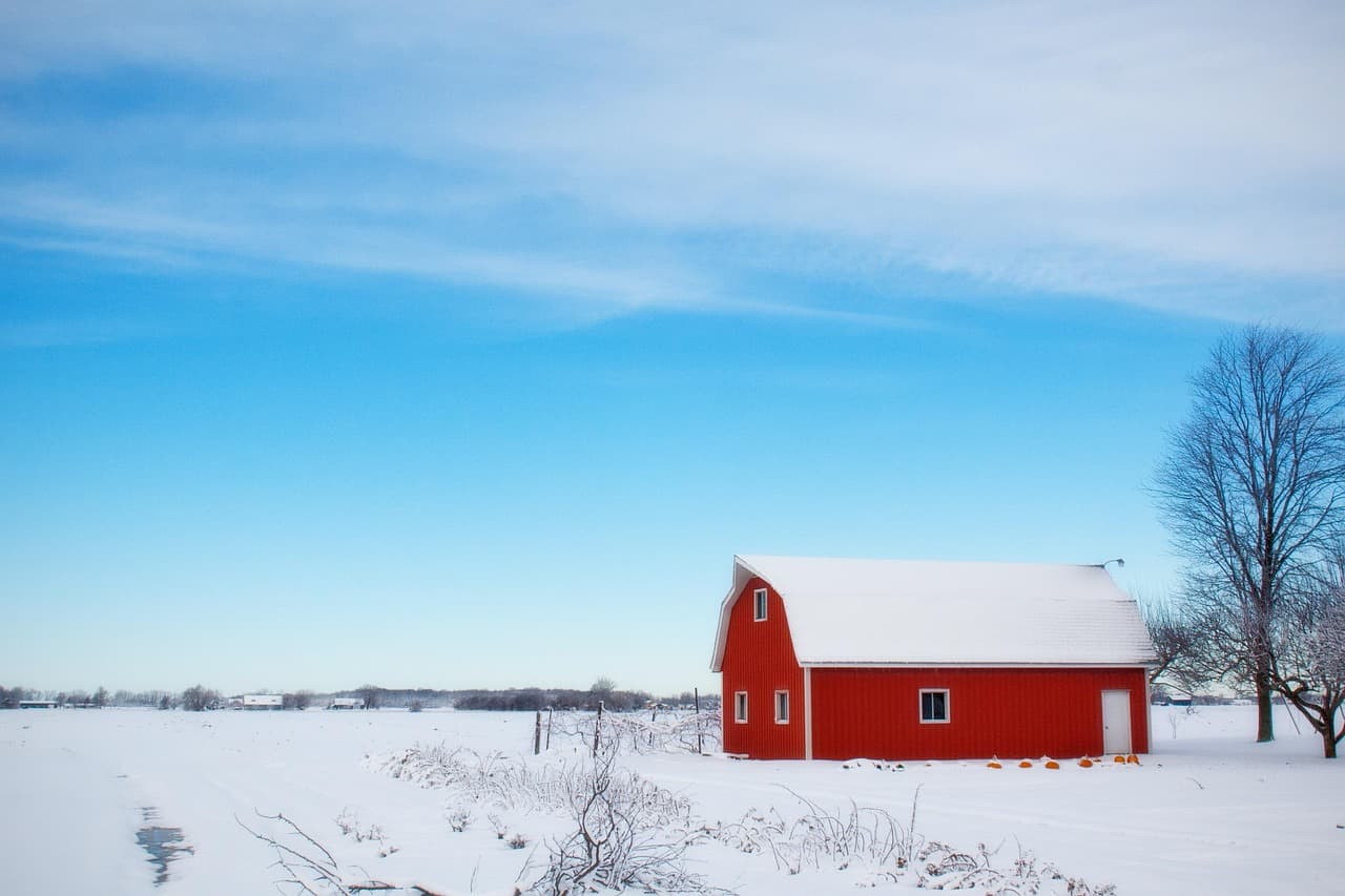 Red hip-roof barn in a Durham Region farm field — Brooklin's family-edge character
