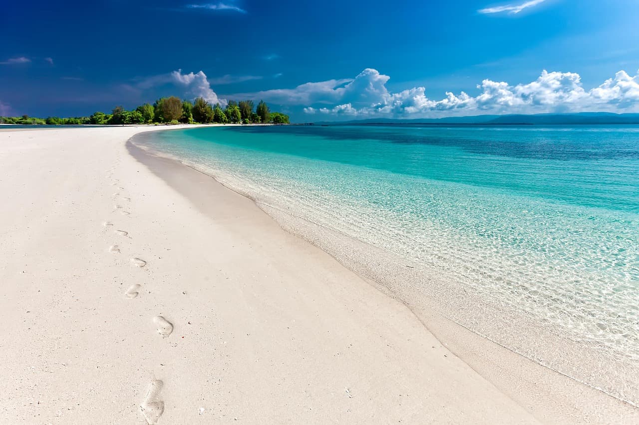 Lake Ontario sandy beach with sailboats and white cliffs in the distance